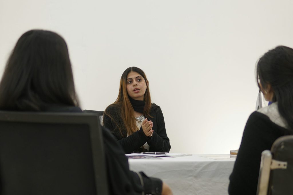 Woman speaking to two people across table